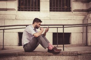 Mann benutzt Smartphone mit Kopfhörern.