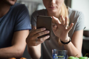 Mädchen tippt auf dem Handy.