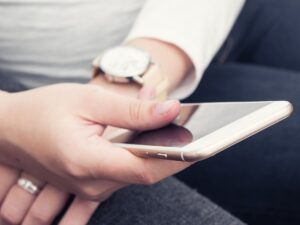 Frau hält Smartphone in der Hand.